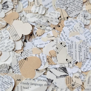 May include: A pile of confetti made from recycled paper. The confetti is in the shape of hearts and music notes. The confetti is in shades of cream and white.