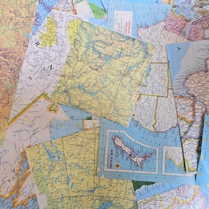 May include: A collage of overlapping vintage paper maps featuring various geographic regions, including New Zealand, Australia, and parts of Africa. The collection displays diverse cartographic styles, color palettes, and printed text labels.