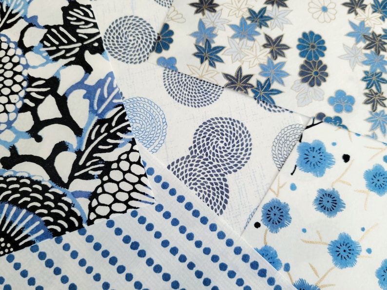 May include: Assortment of blue and white patterned fabric squares. The patterns include a floral design, a swirling pattern, a polka dot pattern, and a geometric pattern.