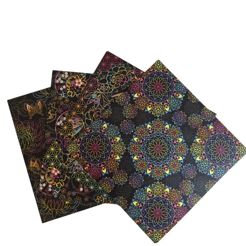 May include: Three black decorative paper sheets with colourful floral and geometric patterns. The designs include butterflies, flowers, and mandala-like shapes in vibrant rainbow colours. The paper has a glossy finish.