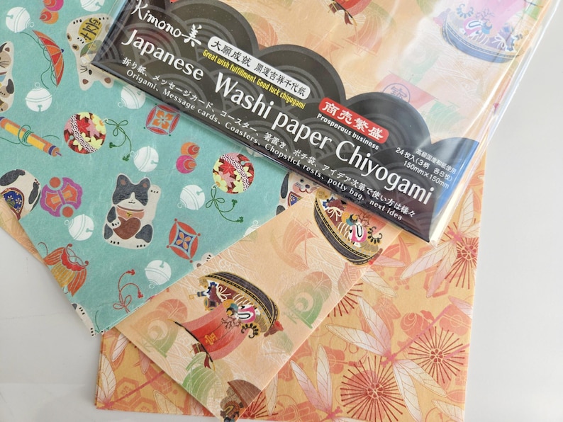 May include: A pack of 24 Japanese Washi paper sheets with a variety of colorful designs. The pack is labeled "Kimono Japanese Washi Paper Chiyogami" and includes the text "Great wish fulfillment. Good luck chiyogami" and "Prosperous business".
