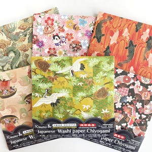 May include: A set of six Japanese washi paper sheets with various traditional designs, including cranes, fish, flowers, and dragons. The paper is gold, red, black, and white. The packaging includes the text "Japanese Washi Paper Chiyogami".