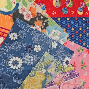 May include: Assortment of colorful patterned fabric squares. Designs include floral, geometric, and traditional Japanese motifs. Colors include blue, red, pink, orange, and yellow. Ideal for crafting, quilting, or decorative projects.