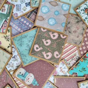 May include: A collection of square paper cards with various Christmas-themed designs. The cards feature images of ornaments, birds, snowmen, and holiday patterns. Each card has a brown border, creating a collage of festive imagery.