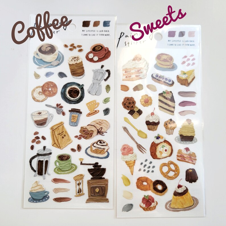 Op de afbeelding: Twee sticker vellen met handgeschilderde illustraties. E&eacute;n vel toont koffie-thema's zoals kopjes, bonen en een molen. Het andere vel toont zoetigheden, waaronder stukken cake, gebak en ijs. De woorden "Coffee" en "Sweets" staan op de vellen.