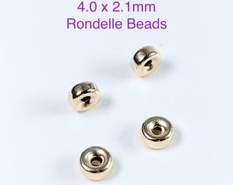 Può includere: Quattro rondelle di metallo dorate, ciascuna misura 4,0 x 2,1 mm, sono sparse su una superficie bianca.  4.0 x 2.1 mm Rondelles Beads