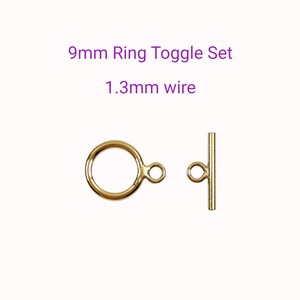 May include: A gold-coloured ring toggle set, featuring a 9mm ring and a 1.3mm wire. The set includes a circular ring with a small connecting loop and a bar with a loop. Text on the image reads "9mm Ring Toggle Set" and "1.3mm wire".