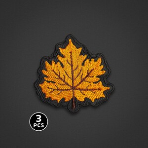 May include: A set of three embroidered patches featuring a yellow and orange maple leaf design with dark brown veins. Each patch has a black stitched border that follows the jagged shape of the leaf. The text 3 PCS is visible in the corner.