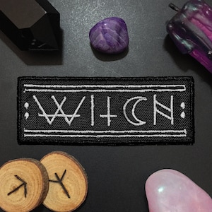May include: Black embroidered patch with white stitching that reads "WITCH" in a stylized font. The patch is surrounded by a white border.