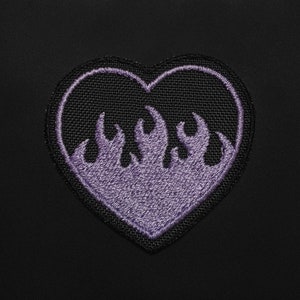 May include: A black heart-shaped patch with a purple embroidered flame design.