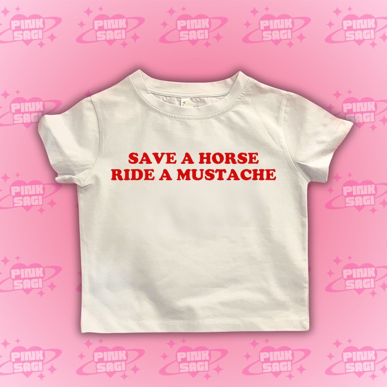Puede incluir: Camiseta blanca con texto rojo que dice "Salva un caballo, monta un bigote".