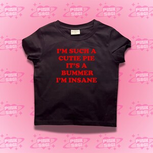 May include: Black t-shirt with red text that reads "I'm such a cutie pie it's a bummer I'm insane."