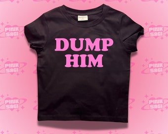 May include: Black t-shirt with pink text that reads "DUMP HIM" on a pink background with a repeating pattern of pink planets with stars.