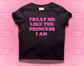 May include: Black t-shirt with pink text that reads "Treat me like the princess I am".