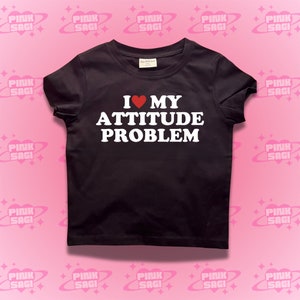 May include: Black t-shirt with white text that reads "I ♥ MY ATTITUDE PROBLEM".
