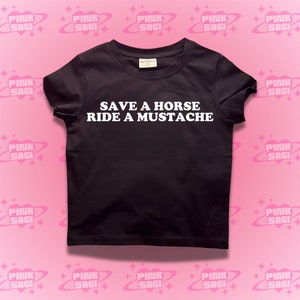 Puede incluir: Camiseta negra con texto blanco que dice "Save a horse, ride a mustache".