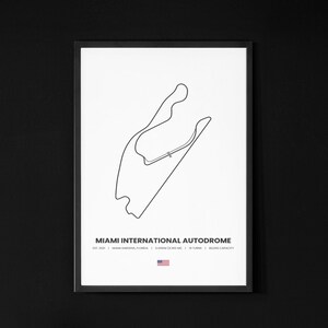 Puede incluir: Impresi&oacute;n enmarcada del circuito del Miami International Autodrome, un dibujo lineal negro sobre fondo blanco. El texto "MIAMI INTERNATIONAL AUTODROME" se encuentra en la parte inferior, junto con detalles y una peque&ntilde;a bandera estadounidense.