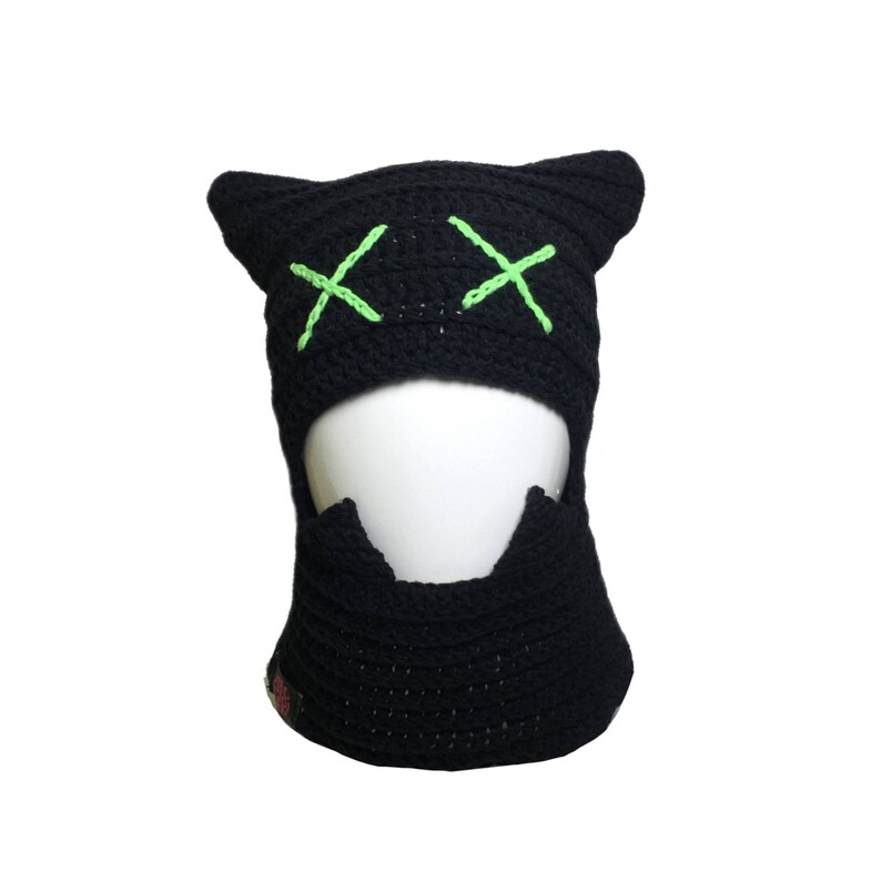 May include: Black crochet balaclava with green X's for eyes.