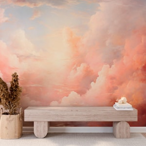 Può includere: Un grande murale raffigurante un cielo sognante dai colori pastello pieno di nuvole soffici nelle tonalità del rosa, pesca e bianco. Una panca in legno chiaro con gambe arrotondate si trova sotto il murale, con un cesto intrecciato e piante essiccate a sinistra.