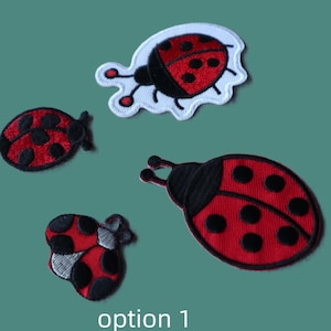May include: Three embroidered ladybug patches in red and black. One patch has a white border, while the others have black outlines. The ladybugs feature black spots on red wings and black heads with antennae. The text "option 1" appears at the bottom.