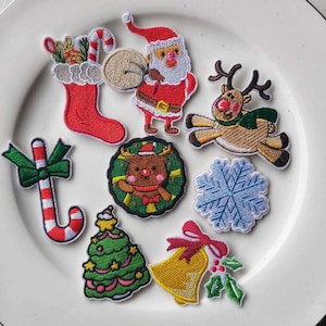 Peut inclure: Un ensemble de dix patchs brodés thermocollants sur le thème de Noël. Les patchs comprennent une chaussette, le Père Noël, un renne, une canne en sucre, un sapin de Noël, un flocon de neige, une couronne et une cloche.