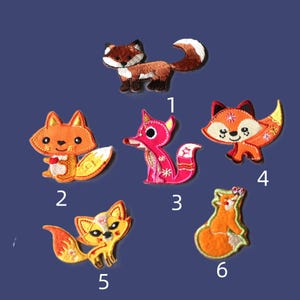 May include: Six embroidered fox patches in various colors and styles. The patches include a brown fox, an orange fox labeled 2, a pink fox labeled 1, an orange fox labeled 4, a yellow fox labeled 5, and an orange fox labeled 6.