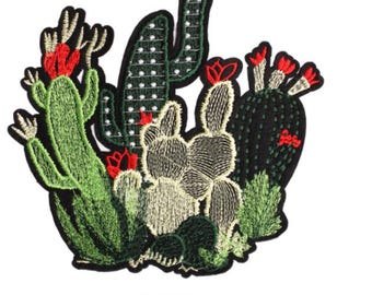 May include: Embroidered iron-on patch featuring a cluster of green, black and white cacti with red flowers. The patch measures 4.3 cm by 4.6 cm.