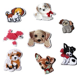 May include: A selection of embroidered dog patches, showcasing different breeds and poses. The patches feature a variety of colours, including brown, white, black, and red. Each patch has a white border, and the dogs are depicted in a cute, cartoonish style.