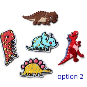 May include: Five embroidered iron-on patches featuring different cartoon dinosaurs. The dinosaurs are a red T-Rex, a blue Triceratops, a yellow Stegosaurus, a brown Ankylosaurus, and a red dinosaur with a spiky back. The patches are all about 5 cm tall.
