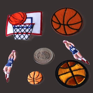 Peut inclure: Un ensemble de huit patchs brodés à repasser représentant des ballons de basket et des joueurs de basket-ball. Les patchs sont de différentes tailles et couleurs, notamment orange, marron, bleu, rouge et blanc.