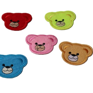 Peut inclure: Cinq écussons en forme d'ours de couleurs vives : rouge, vert, rose, bleu et beige. Chaque écusson présente un visage brodé noir et une bouche brodée blanche. Idéal pour décorer des vêtements ou des accessoires.