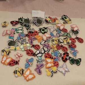 Peut inclure: Une collection de patchs thermocollants colorés représentant différents motifs d'insectes, notamment des papillons, des coccinelles, des abeilles et des araignées. Les patchs sont parfaits pour ajouter une touche fantaisiste aux vêtements, aux sacs ou à d'autres articles en tissu.