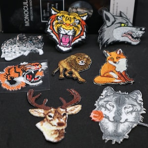 May include: A set of ten embroidered iron-on patches featuring various animals, including a tiger, wolf, lion, deer, and fox. The patches are colorful and detailed, and would be perfect for adding a touch of personality to clothing, bags, or other accessories.