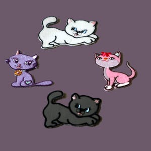 May include: Four embroidered cat patches in different colors. One white cat stretching, one purple cat sitting with a flower collar, one pink cat with a red bow, and one dark gray cat stretching. Each patch features detailed stitching and cartoon-style faces.