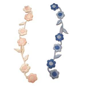 May include: Two embroidered flower vine patches, one in pink and white and one in blue. The patches are ideal for adding a touch of whimsy to clothing, bags, or other crafts.
