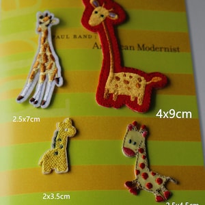 May include: Four embroidered iron-on patches of giraffes in different sizes and colours. The patches are on a yellow and green striped background. The patches measure 2.5x7cm, 2x3.5cm, 4x9cm, and 2.5x4.5cm.