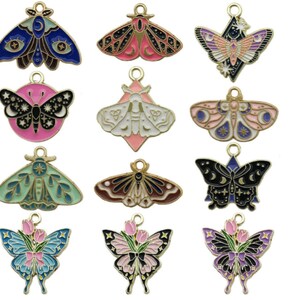 Peut inclure: Douze breloques en émail de papillon colorés avec différents motifs, notamment des motifs de lune, d'étoiles et floraux. Ces breloques sont parfaites pour la fabrication de bijoux, le scrapbooking et d'autres projets d'artisanat.