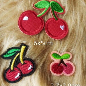 May include: Three embroidered iron-on patches of cherries. The largest patch is red with green leaves and measures 6x5 cm. The medium patch is red with green leaves and measures 4.6x3.5 cm. The smallest patch is pink with green leaves and measures 2.7x2.9 cm.
