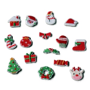 May include: A collection of fifteen small embroidered Christmas-themed patches featuring a house, Santa Claus, a snowman, a hat, a candy cane, a gift bag, a bow, a mitten, a stocking, holly, a gift box, a tree, a candy, a wreath, and a reindeer.