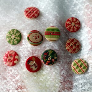 May include: A selection of festive Christmas buttons in red, green, and white. The buttons display patterns such as snowflakes, Christmas trees, and Santa Claus. Ideal for seasonal crafts and adding a touch of holiday cheer to projects.