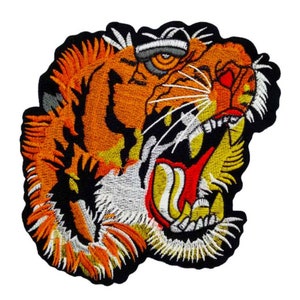 May include: Embroidered iron-on patch featuring a detailed tiger head with an open mouth, sharp teeth, and a fierce expression. The tiger's fur is orange, black, and white, with a yellow and red mouth.