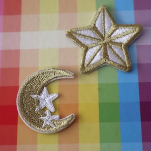May include: Two gold embroidered iron-on patches, one a crescent moon with two white stars and the other a white star with gold outlines.