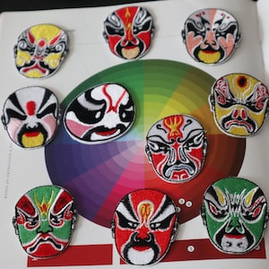 May include: Nine embroidered patches of colorful Chinese opera masks. The masks are all different colors and designs, and they are all set against a white background.