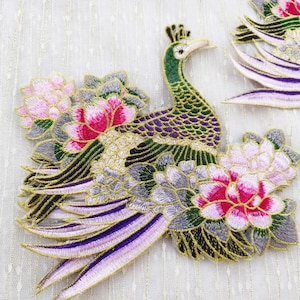 Peut inclure: Paon brodé avec des fleurs roses et blanches. Le paon est vert, violet et or. Les fleurs sont détaillées avec du fil d'or.