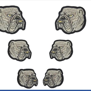May include: Six embroidered patches of a bulldog's face with a black outline and grey fur. The bulldog has a yellow nose and a yellow tongue.