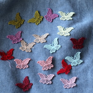 May include: Assortment of colorful lace butterfly appliques in various shades of pink, red, green, and blue. These delicate embellishments are perfect for adding a touch of whimsy to clothing, accessories, or crafts.