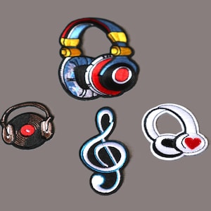 May include: Five embroidered iron-on patches featuring music-themed designs. The patches include a pair of headphones, a treble clef, and two different styles of headphones with a red heart.