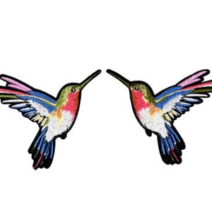 Peut inclure: Deux patchs brodés à repasser représentant des colibris colorés. Les colibris sont tournés dans des directions opposées et présentent des détails roses, bleus, verts et blancs.