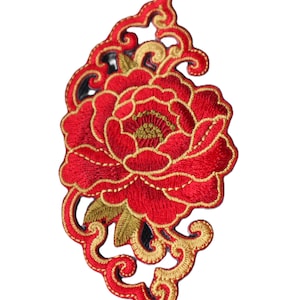 May include: Embroidered red peony flower patch with gold accents and decorative swirling border. The floral design features detailed stitching and a black backing. This patch is suitable for clothing and craft projects.