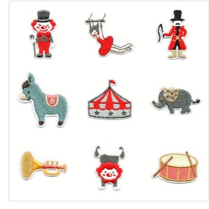 May include: Nine embroidered iron-on patches featuring circus themes. The patches include a clown, a trapeze artist, a ringmaster, a donkey, a circus tent, an elephant, a trumpet, a clown with a lion mane, and a drum.